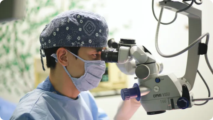 Sky Eye Clinic surgeon looking through an operating microscope during eye surgery