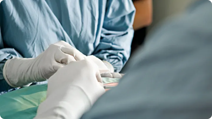 Gloved surgeon hands during a sterile eye surgery procedure