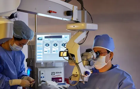 Surgeons performing retinal vitrectomy surgery under an operating microscope