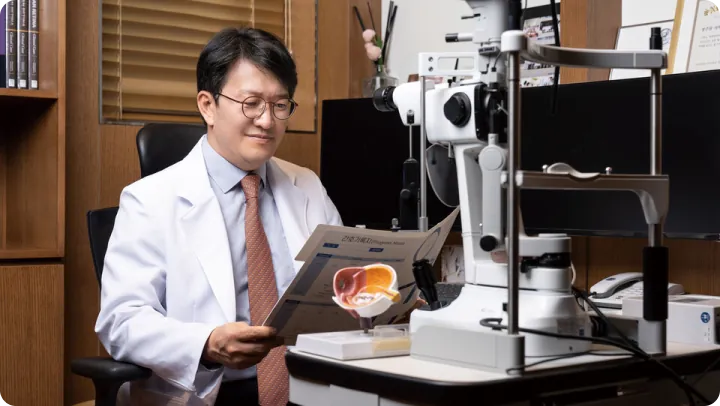 Retina doctor reviewing an eye model next to a slit lamp during a retina consultation at Sky Eye Clinic