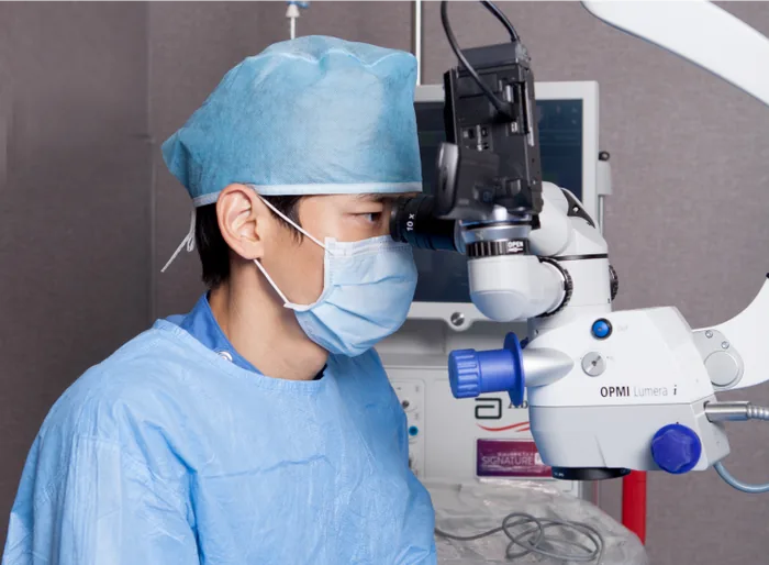 Surgeon using an operating microscope during implantable lens surgery